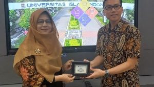 Prof Elisa Kusrini memberikan kenang-kenangan kepada Prof Muhammad Aziz. (foto : istimewa)