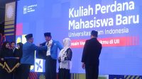 Rektor UII mengenakan jas almamater kepada mahasiswa baru di Lapangan Utara Gedung Olahraga (GOR) Ki Bagoes Hadikoesoemo, Kampus Terpadu UII, Selasa (2/9/2025). (foto : heri purwata)