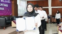 Mahasiswi memperlihatkan Sertifikat Pencegahan dan Pendeteksian Fraud. (foto : istimewa)