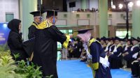 Rektor UII memindahkan kucir toga sebagai prosesi wisuda. (foto : Humas UII)