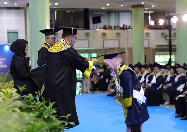 Rektor UII memindahkan kucir toga sebagai prosesi wisuda. (foto : Humas UII)