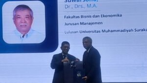 Suwarsono Muhammad doktor tertua 2025 UII menerima bingkisan dari Prof Dr Zaenal Arifin, MSi, Wakil Rektor Bidang Sumber Daya & Pengembangan Karier UII. (foto : heri purwata)