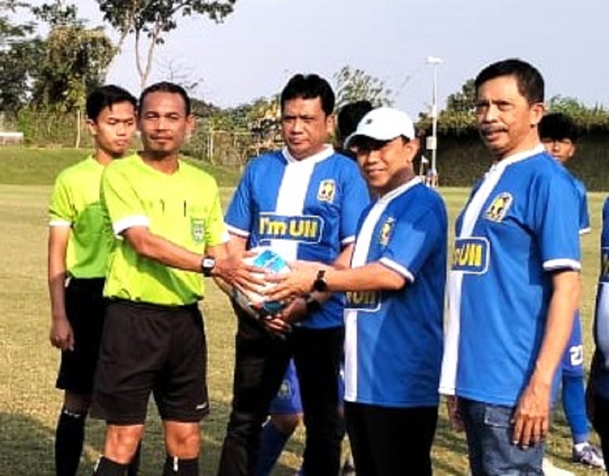 Rektor UII, Prof Hari Purnomo menyerahkan bola kepada wasit tandai pembukaan pertandingan antara UNISI FC melawan PSTN di lapangan sepakbola UII, Selasa (28/7/2026). (foto : istimewa)
