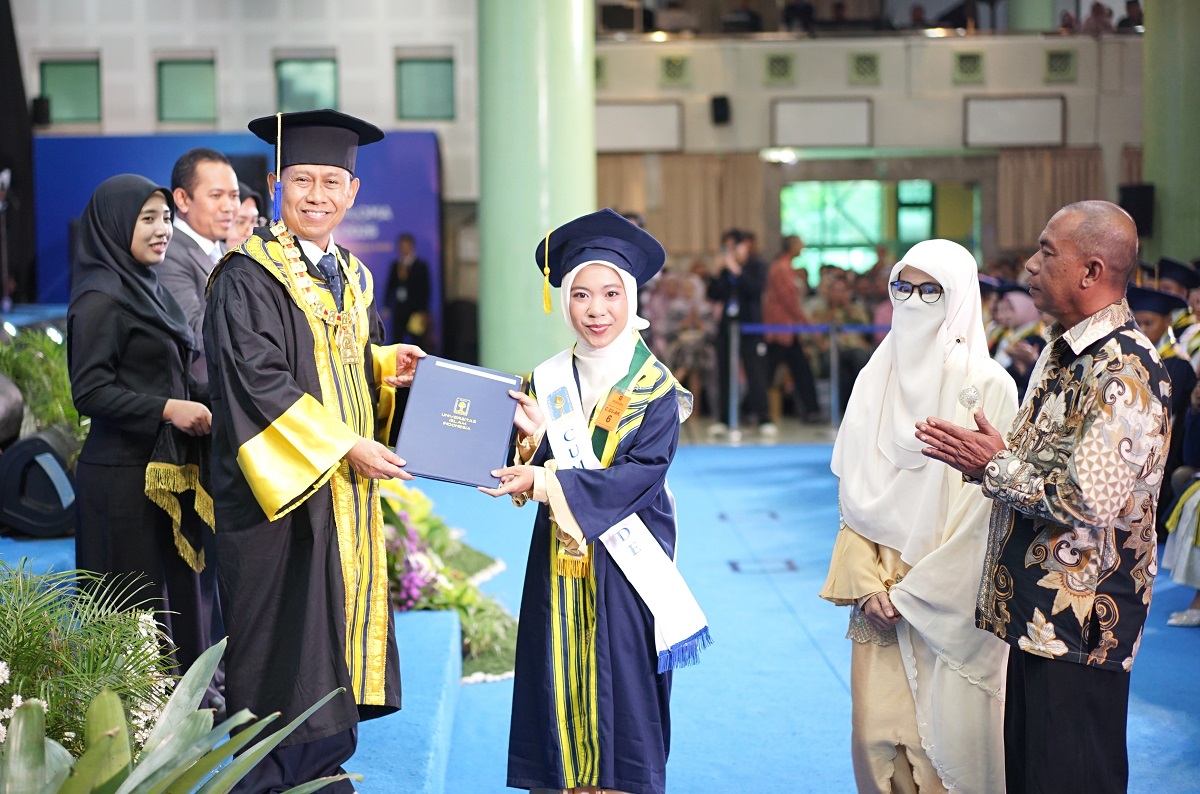 Prof Hari Purnomo menyerahkan ijazah dan Pin Emas kepada wisudawati terbaik yang disaksikan kedua orangtuanya. (foto : istimewa)