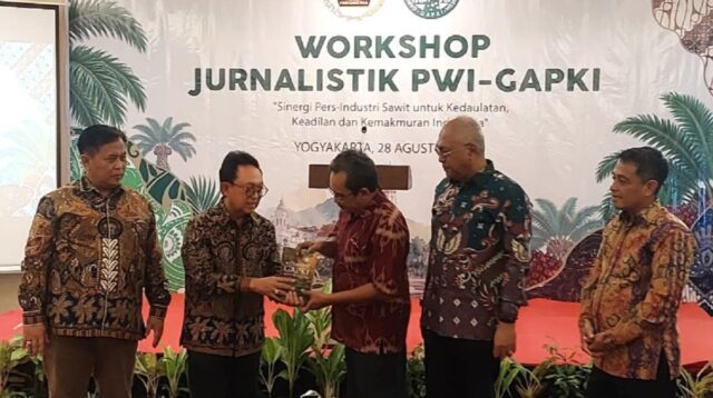 Edy Martono (kiri) menyerahkan kenang-kenangan berupa Buku '45 Tahun GAPKI untuk Negeri kepada Hudono. (foto : heri purwata)