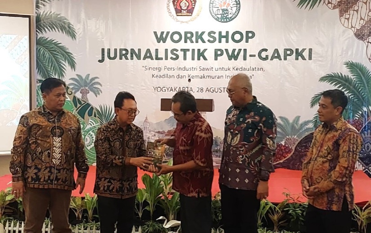 Edy Martono (kiri) menyerahkan kenang-kenangan berupa Buku '45 Tahun GAPKI untuk Negeri kepada Hudono. (foto : heri purwata)