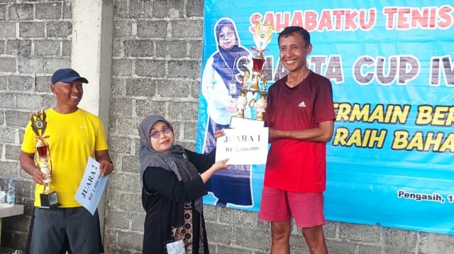 Kepala Sekolah SMAN I Pengasih, Erna Kurnia Wati menyerahkan tropi dan uang pembinaan kepada para juara. (foto : heri purwata)
