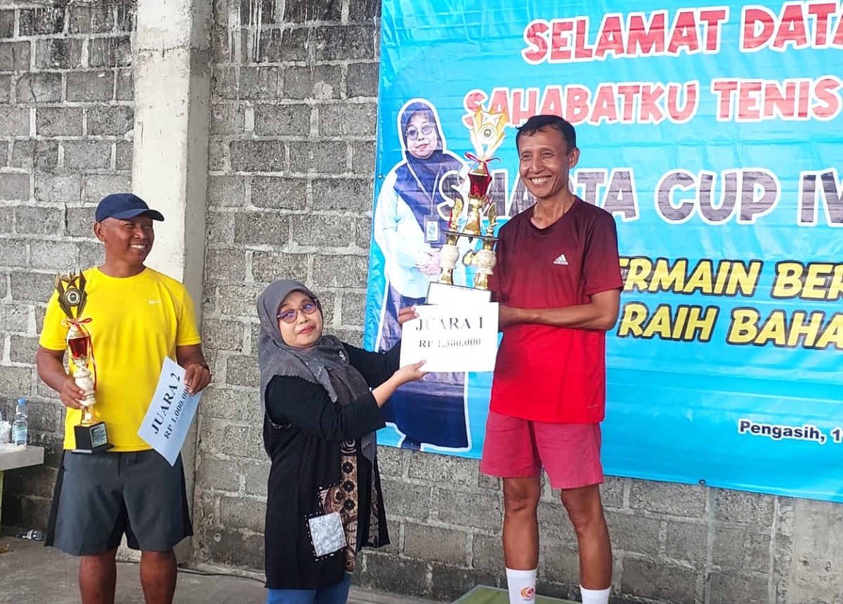 Juara I SMAPTA Cup IV Kepala Sekolah SMAN I Pengasih, Erna Kurnia Wati menyerahkan tropi dan uang pembinaan kepada para juara. (foto : heri purwata)